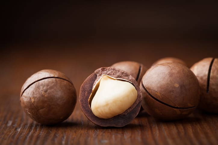 Macro shot of macadamia nuts on wooden table.