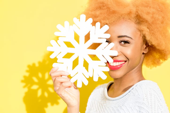 Portrait of a woman with artificial snowflake on the yellow background